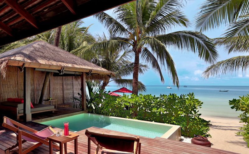 Terrasse der Ocean Pool Villa Ein luxuriöses Strandresort mit privatem Pool, von tropischen Pflanzen und Palmen umgeben, mit Blick auf das ruhige, türkisfarbene Meer.
