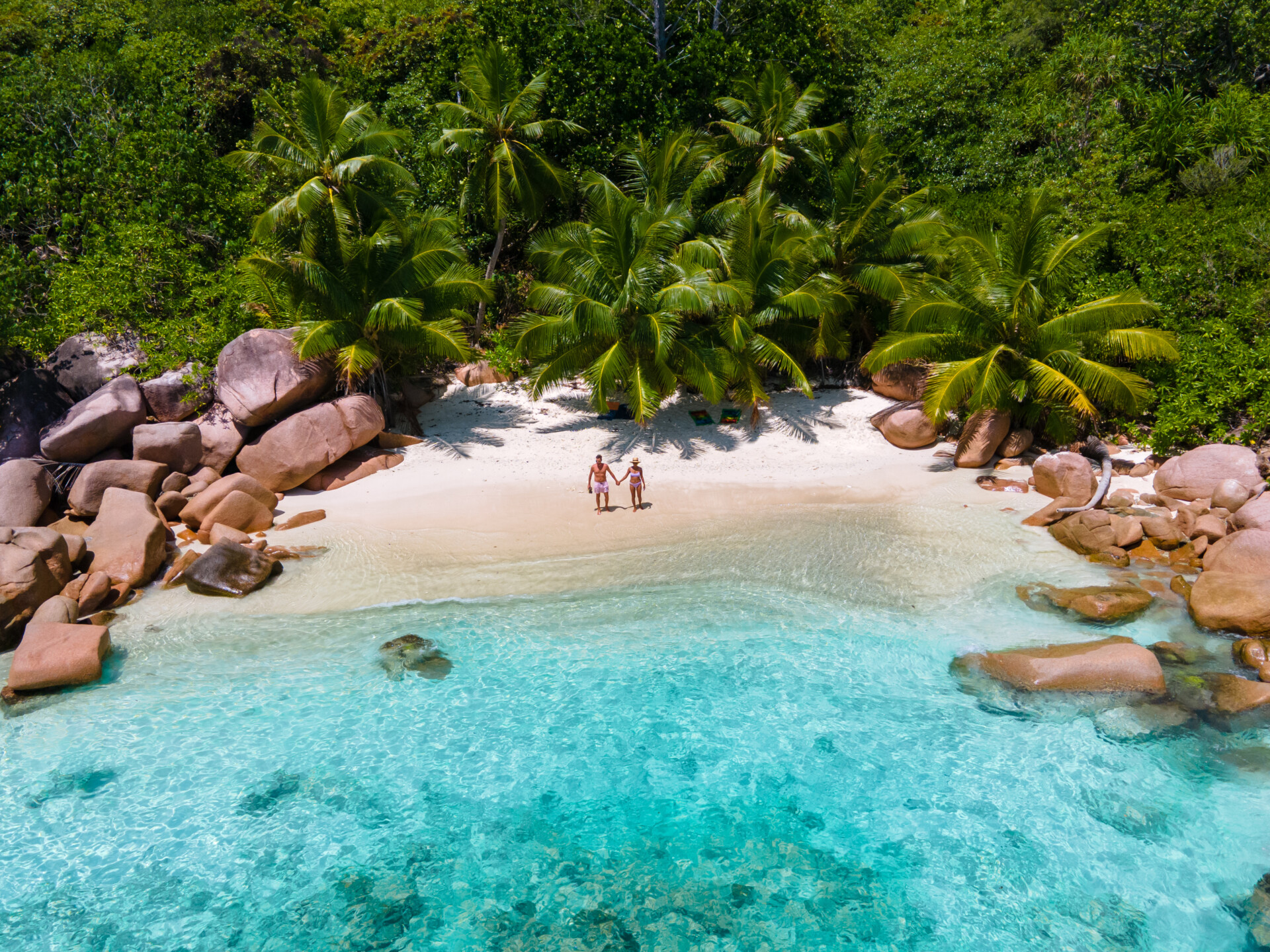 Slide: Startseite 1: Anse Source d’Argent, La Digue Seychelles, young couple men and woman on a tropical beach during a luxury vacation in the Seychelles. Tropical beach Anse Source d’Argent, La Digue Seychelles